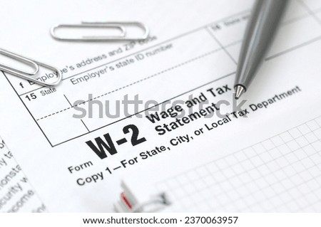 The pen and notebook on the tax form W-2 Wage and Tax Statement. The time to pay taxes Royalty-Free Stock Photo #2370063957