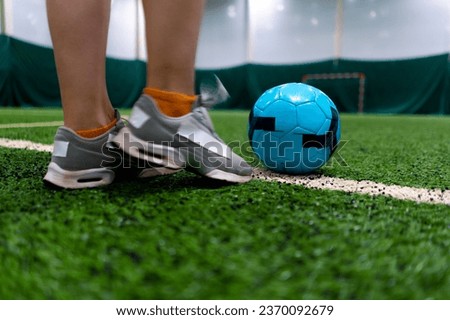 close-up of a soccer player's foot kicking the ball for a penalty or a goal or passing a ball on green synthetic grass during football game