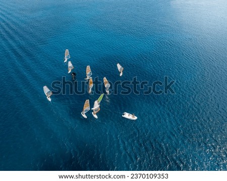 Aerial view of a windsurfing school training over turquoise sea with copy space Royalty-Free Stock Photo #2370109353