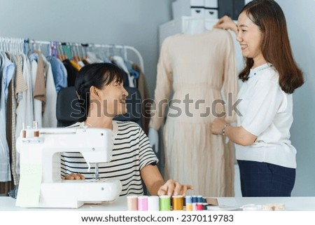 Happy beautiful Asian young woman working in the fashion design studio, professional female fashion designer portrait in design studio.