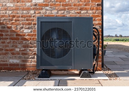 Air Source heat pump fitted outside a new home Royalty-Free Stock Photo #2370122031