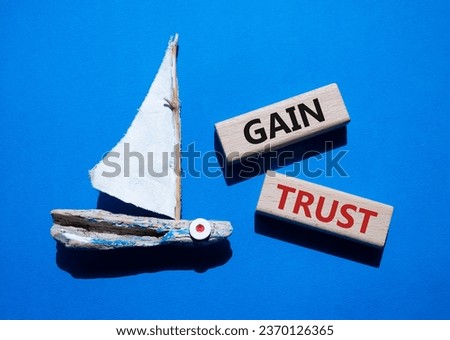 Gain trust symbol. Wooden blocks with words Gain trust. Beautiful blue background with boat. Business and Gain trust concept. Copy space.