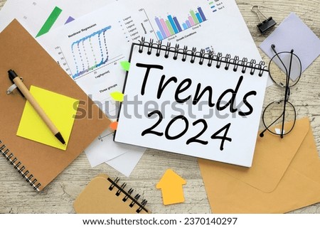 notepad with spring and glasses. bright financial charts. text 2024 trends Royalty-Free Stock Photo #2370140297