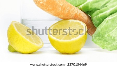Discover the perfect ingredients for a healthy lifestyle with this captivating image featuring two juicy lemons, a glass of water, a nutritious carrot, and vibrant chard. Ideal for stock agencies.