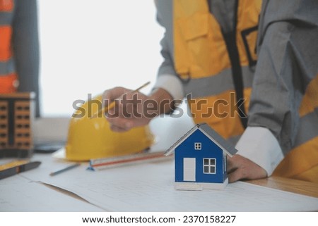 Construction and structure concept of Engineer or architect meeting for project working with partner and engineering tools on model building and blueprint in working site, contract for both companies.