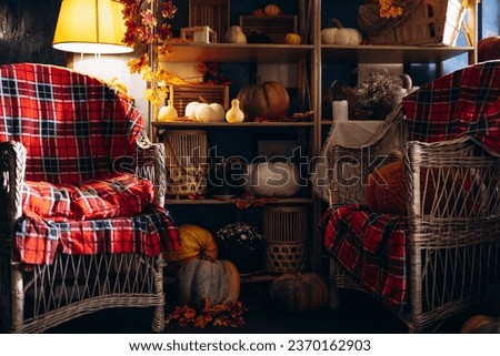 Pumpkin decorations with hay, baskets, and cozy chair place