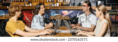 young team working using their laptops with blurred bar on background, coworking concept, banner
