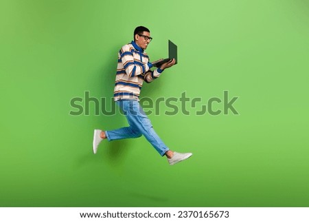 Full body photo of man jumping professional it company workaholic hurry with hp netbook advertisement isolated on green color background