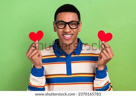 Photo of toothy smile young boyfriend show his sympathy amour sentiment red paper postcards heart figure isolated on green color background Royalty-Free Stock Photo #2370165783