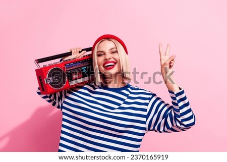 Photo of pretty cheerful lady wear striped shirt listening boom box showing v-sign isolated pink color background