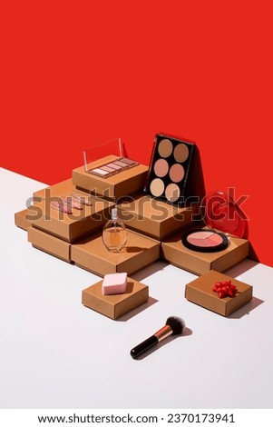 Kraft paper gift boxes and makeup products flat lay on red and white background