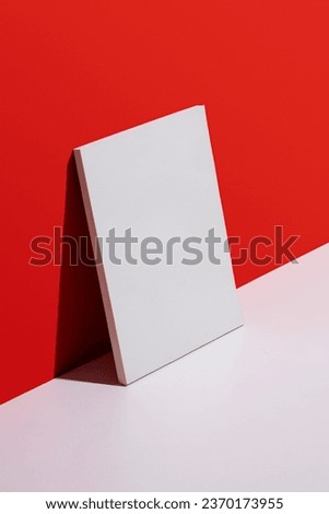 White blank cover magazine mockup lean over red and white background