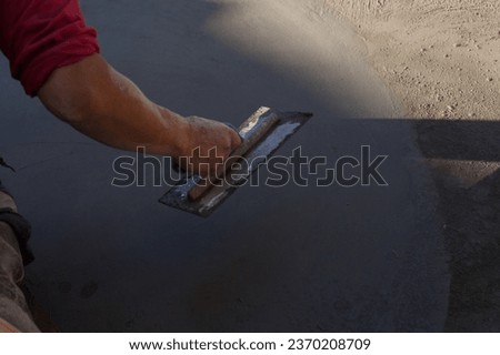 Close-up photo of a hand finishing a cement slab. Construction concept.