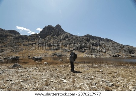 Picture of young tourist in the Andes and a lagoon. Concept of travel and tourism.