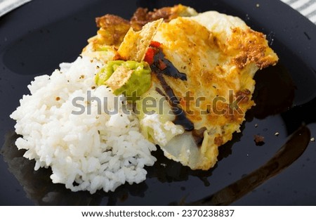 Image of vegetarian dish of leaves of cabbage in batter with rice and green sauce
