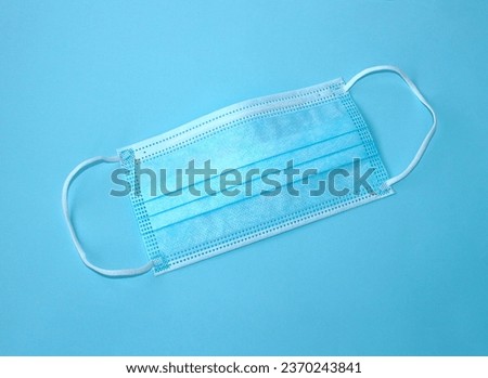 Medical surgical mask with rubber earmuffs. A three-layer mask provides reliable protection against viruses, infections and bacteria. Pandemic Coronavirus. Medical protection  concept. Top view.