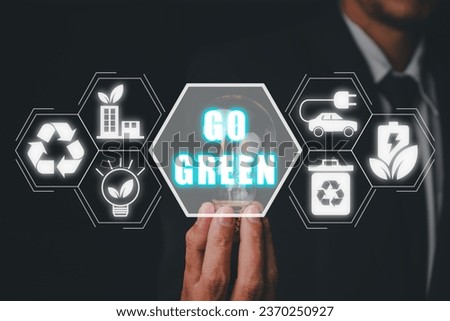 Go green concept, Businessman hand holding light bulb with go green icon on virtual screen.