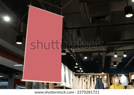 Red blank sign for text inside shopping mall. mock up advertise display frame setting over the clothes line in the shopping department store for shopping, business fashion and advertisement concept.