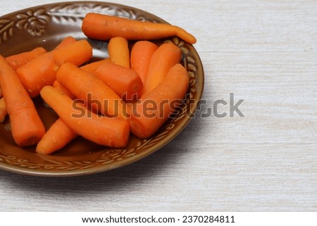 Some carrots have been boiled, served on a brown plate. The concept of vegetarian food and healthy natural food. Selected focus. In the room.