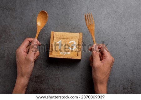 Left handed person holding the spoon on left side.Left hander day concept. 
