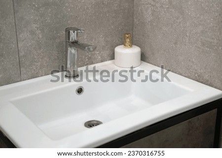 Modern sink. Stylish white sink with Faucets in modern interior. Water tap made of chrome material. Domestic Appliances. Gray bathroom. household equipment. Water Tap. Contemporary style