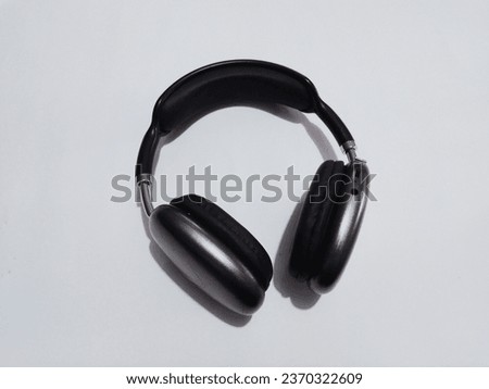 A black headphone isolated on a white background. Technology concept and idea.
