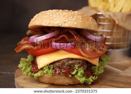 Tasty burger with bacon, vegetables and patty on wooden table, closeup