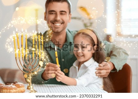 Happy father and daughter lighting candles for Hannukah at home Royalty-Free Stock Photo #2370332291
