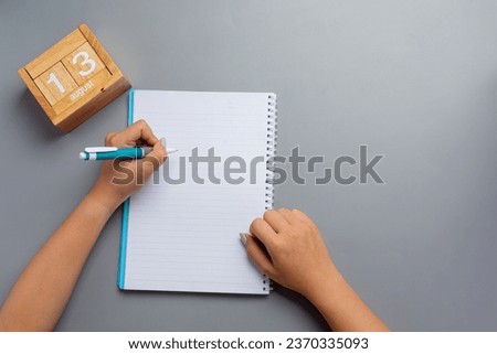 a woman left-hand with a pen.Left hander day concept.  Royalty-Free Stock Photo #2370335093
