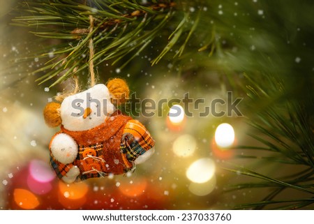 Toy Snowman In The Warm Clothing on The Christmas Tree and Decoration Candle Light