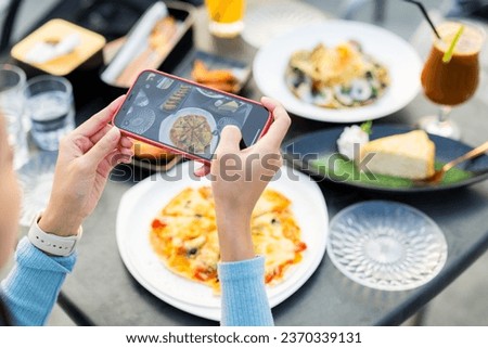 Woman cellphone to take photo on the food in restaurant 