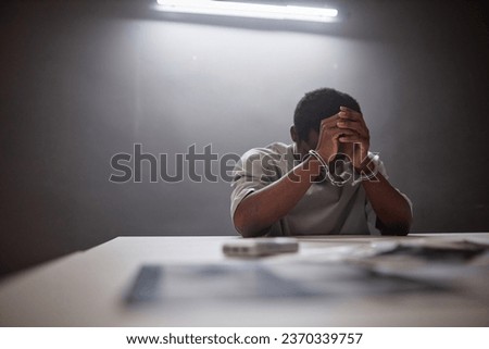 Minimal portrait of Black young man wearing handcuffs crying in remorse as criminal arrested, copy space Royalty-Free Stock Photo #2370339757