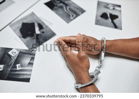 Top view closeup of criminal wearing handcuffs at table during interrogation in police department, copy space