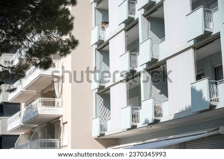Apartment windows, doors, balcony and railing in the sun Royalty-Free Stock Photo #2370345993