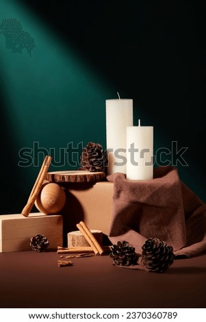 Concept of Christmas season with white candles displayed with few cinnamon sticks, pine cones and tree pieces. Merry Christmas and happy new year concept