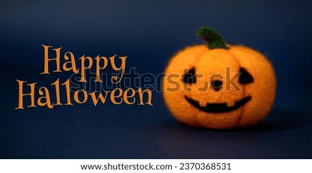 Happy Halloween greeting text on blue background. Woolen felting toys Jack o lantern pumpkin head.