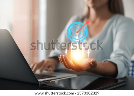 Business goal success concept, businesswoman hold symbol of digital marketing and target of leadership, unlock your goals with strategy, planning and goals. Suitable for business concept.