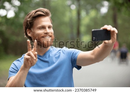happy man taking selfie and hiking in forest