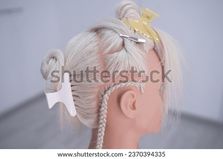 marking a mannequin's head into zones, hairdressing, teaching students, hair cutting, braiding. The master demonstrates to his students the division of the head into zones Royalty-Free Stock Photo #2370394335