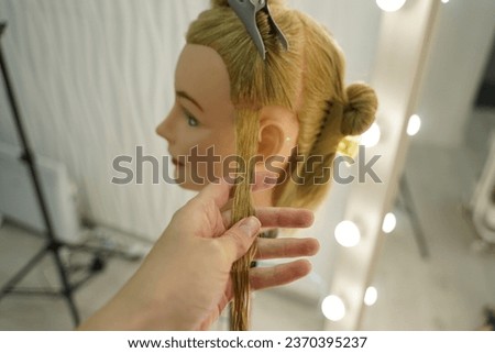 marking a mannequin's head into zones, hairdressing, teaching students, hair cutting, braiding. The master demonstrates to his students the division of the head into zones Royalty-Free Stock Photo #2370395237
