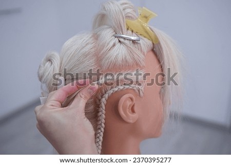 marking a mannequin's head into zones, hairdressing, teaching students, hair cutting, braiding. The master demonstrates to his students the division of the head into zones Royalty-Free Stock Photo #2370395277