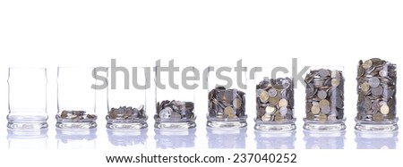 Glass jars with coins like diagram, isolated - savings concept Royalty-Free Stock Photo #237040252