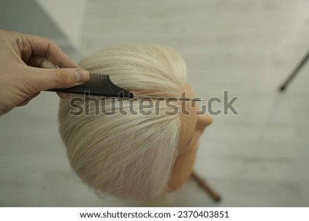 marking a mannequin's head into zones, hairdressing, teaching students, hair cutting, braiding. The master demonstrates to his students the division of the head into zones Royalty-Free Stock Photo #2370403851