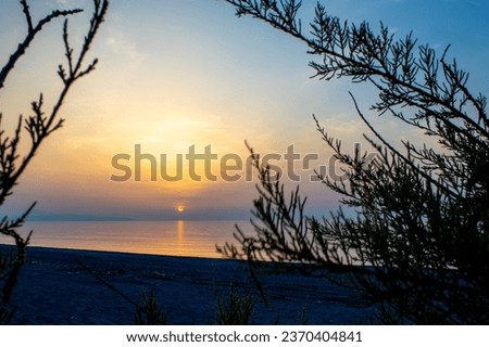 Rays of the sun shine through the clouds. Magnificent panorama of sunset over the ocean.