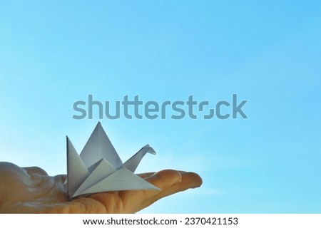 White paper origami bird on blue sky background. World Day of Peace. Day Against Humiliation. International Day Of Human Fraternity. International Day of Living Together in Peace