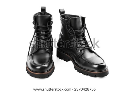 Pair of black leather boots, dress boots for men. Black brogue boots on a white background. Man's legs in black jeans and brown leather boots. Royalty-Free Stock Photo #2370428755