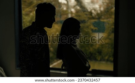 Indian stressed upset tense husband wife arguing fighting shouting on each other at dark indoor home. Silhouette angry sad boyfriend girlfriend quarreling screaming on family problems in evening house Royalty-Free Stock Photo #2370432457