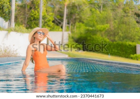 Portrait beautiful young asian woman relax smile leisure around outdoor swimming pool in hotel resort on travel vacation