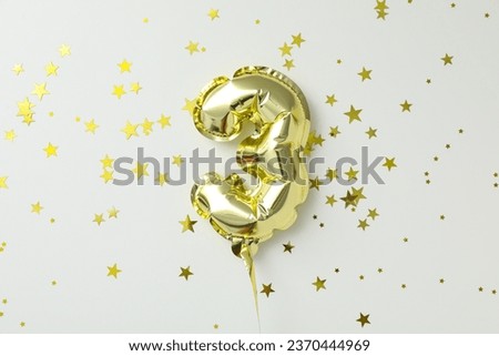 Festive number 3 made of golden balloons