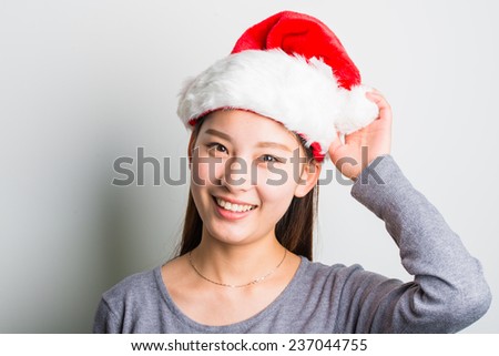 Young happy woman smile with Christmas hat and grey sweater isolated on white.